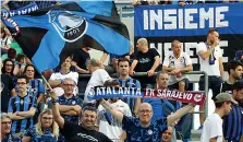  ??  ?? Il gadget Un supporter atalantino, ieri allo stadio di Reggio, mostra la «doppia» sciarpa destinata a diventare un cimelio