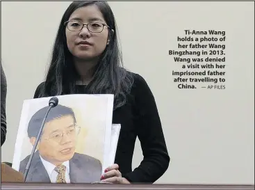  ?? — AP FILES ?? Ti-Anna Wang holds a photo of her father Wang Bingzhang in 2013. Wang was denied a visit with her imprisoned father after travelling to China.