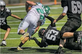  ?? JIM WEBER/THE NEW MEXICAN ?? Jaguars Ernesto Valencia, below, pulls down Moriarty running back Kenneth Poyner during Capital’s 35-34 win over Moriarty on Saturday at Capital.