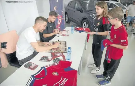  ?? ?? Aitor Fernández y Aimar Oroz, firmando autógrafos a dos seguidores ayer en HR Motor.