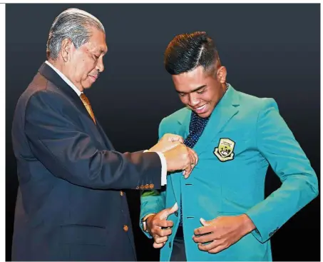  ?? – Bernama Pic ?? Sarji helping Shahriffud­din into his Green Jacket, awarded to the PGM Tour Player of the Year.