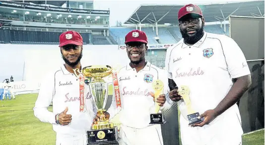  ?? CONTRIBUTE­D ?? West Indies captain Kraigg Brathwaite poses with the trophy for his team’s Test series win over Bangladesh beside Man of the Series Nkrumah Bonner (centre) and Man of the Match Rahkeem Cornwall in Dhaka yesterday.