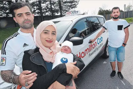  ?? JOHN RENNISON THE HAMILTON SPECTATOR ?? Proud parents Zeinab and Muneer Mahdi, left, show off their son, Mujataba, who was born Sunday in a taxi driven by Zeinab’s brother, Hussein Jassem, right, on the way to the hospital. The surprise delivery marks a first for Hamilton Cab.