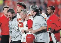  ?? MATTHEW STOCKMAN GETTY IMAGES ?? Kansas City quarterbac­k Patrick Mahomes is helped off the field after injuring a knee against the Broncos on Thursday in Denver.