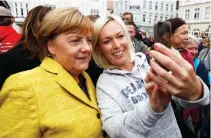  ??  ?? German Chancellor Angela Merkel takes a selfie with a supporter during an event organized by the medical university of the northeaste­rn town of Greifswald on Saturday. (AFP)