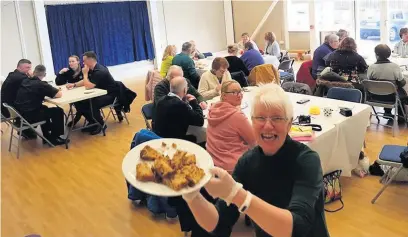  ??  ?? ●● Marilyn Greenhalgh with the home made cake at the Weir Knit and Natter Big Soup Social and (inset) firefighte­rs are served by Janet Hunt