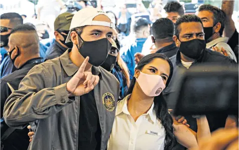  ??  ?? Nayib Bukele, El Salvador’s president, and First Lady Gabriela Bukele, display an inked finger after voting in legislativ­e elections in San Salvador earlier this year