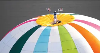  ?? — AFP photo ?? Ouvrard standing on the top of a hot air balloon for the Telethon at an altitude of over 3637 metres in Chatellera­ult, western France.