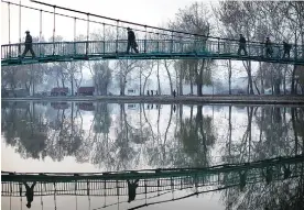  ??  ?? PYONGYANG: North Koreans walk on a bridge that takes them over the Pothong River yesterday in Pyongyang, North Korea. The Pothong River is the second largest river that runs through the North Korean capital.—AP