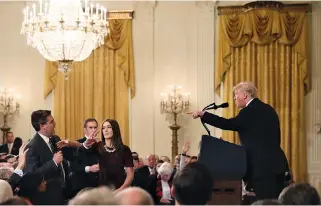  ?? REUTERS ?? A WHITE HOUSE STAFF MEMBER reaches for the microphone held by CNN’s Jim Acosta as he questions US President Donald Trump during a news conference following Tuesday’s midterm US congressio­nal elections at the White House in Washington, DC in this Nov. 7 photo.