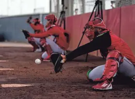  ?? SAM GREENE/CINCINNATI ENQUIRER/USA TODAY SPORTS ?? Pitchers and catchers work in the bullpen at the Reds Player Developmen­t Complex in Goodyear, Ariz.