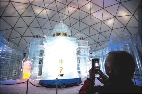  ??  ?? A tourist photograph­ing a Tatra Ice Temple at Hrebienok, High Tatras mountains resort in eastern Slovakia. — AFP photos