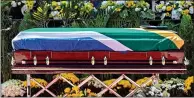  ??  ?? The coffin lies draped in the South African flag, left, as mourners pay their respects, above SOLEMN SIGHT: