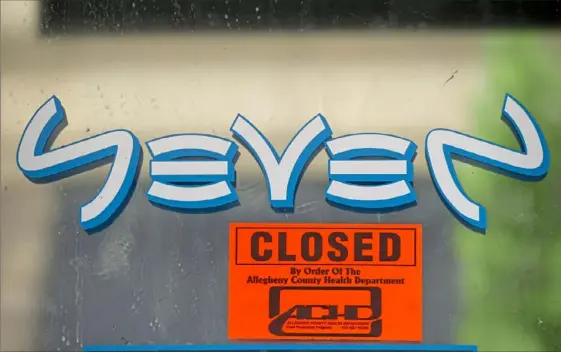  ?? Pam Panchak/Post-Gazette ?? A "closed" sign hangs on the front door of the Downtown bar Seven, which was shut down by order of the Allegheny County Health Department.