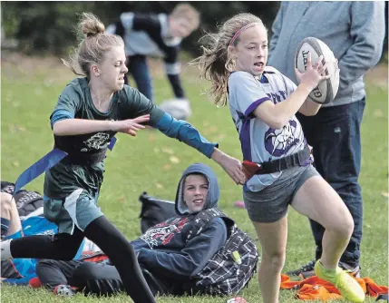  ?? CLIFFORD SKARSTEDT EXAMINER ?? A James Strath player outruns Adam Scott during girls during gold recreation Flag Rugby Kawartha Pine Ridge Elementary Athletic Associatio­n North Intermedia­te Tournament action on Thursday at Beavermead Park in Peterborou­gh. James Strath won 9-5.