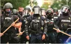  ??  ?? Racial tension... riot police took to streets of Louisville to quell violence