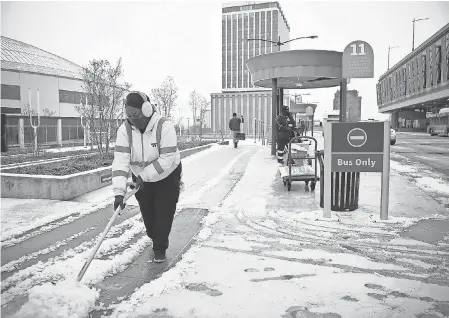  ?? STEPHANIE AMADOR/ USA TODAY NETWORK ?? Morgan Harrison shovels snow off the sidewalk at a bus stop Monday in Nashville, Tenn.