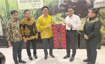  ?? ?? Jaziri (third left) presents a ‘Pua Kumbu’ cloth to Sandiaga as a memento.