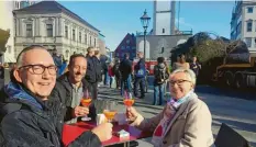  ?? Foto: Ina Marks ?? Rüdiger Holfelder, Stefan Deffner und Bianca Redante (von links) beobachten beim Aperol Spritz, wie der Christbaum aufgestell­t wird.