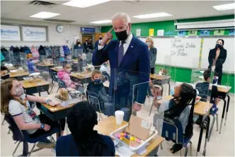  ?? The Associated Press ?? ■ In this Monday photo, President Joe Biden gestures as he talks to students during a visit to Yorktown Elementary School, in Yorktown, Va., as first lady Jill Biden watches. Biden has met his goal of having most elementary and middle schools open for full, in-person learning in his first 100 days.