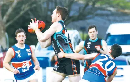  ??  ?? Right: Bunyip’s Jake Buckingham and Lachlan Petch battle for the ball with Cora Lynn opponent Ryan Gillis; Photogprap­hs: Tom Elton