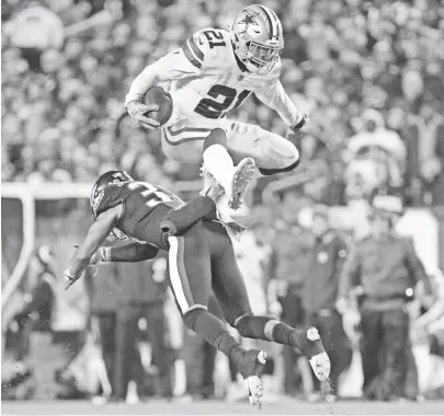  ?? BILL STREICHER/USA TODAY SPORTS ?? Cowboys running back Ezekiel Elliott leaps over the tackle attempt of Eagles defensive back Tre Sullivan on Nov. 11 at Lincoln Financial Field.