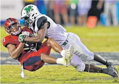  ?? JIM RASSOL/STAFF FILE PHOTO ?? Florida Atlantic safety Jalen Young, left, here intercepti­ng a pass against Marshall, wears the No. 18 to honor his brother who has fought back from a near fatal shooting.