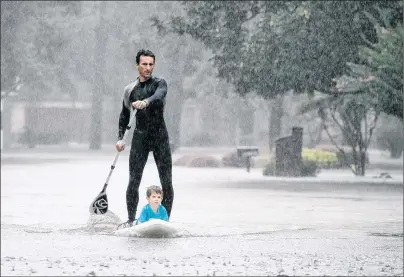  ?? AP PHOTO ?? Alexendre Jorge evacuates Ethan Colman, 4, from a neighborho­od inundated by floodwater­s from tropical storm Harvey on Monday in Houston, Texas.