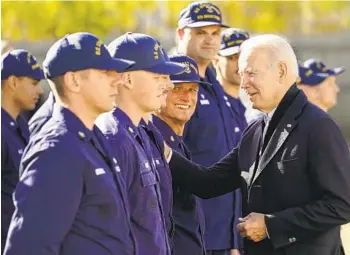  ?? CAROLYN KASTER AP ?? President Joe Biden greets members of the Coast Guard at the Brant Point station in Nantucket, Mass., on Thursday after virtually meeting with service members from around the world for Thanksgivi­ng.