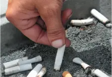  ?? AP FILE PHOTO ?? A smoker extinguish­es a cigarette in an ash tray in Sacramento, Calif., in 2012.