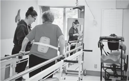  ??  ?? On the road to rehabilita­tion, a patient walks with the help of parallel bars. About 1,000 people each year suffer a stroke in the Island Health region. A stroke results from a blocked blood vessel that would otherwise supply an area of the brain with...