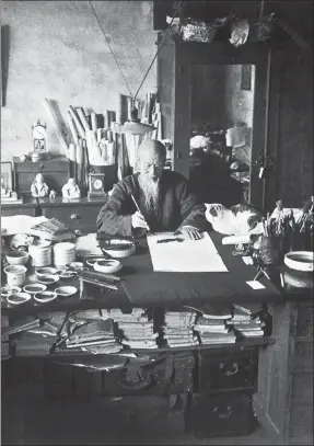  ?? PHOTOS PROVIDED TO CHINA DAILY ?? Qi Baishi paints at his Beijing residence, accompanie­d by his cat.