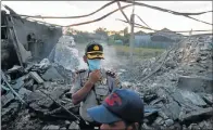  ?? Picture: REUTERS/ BEAWIHARTA ?? GRIM SCENE: Policemen inspect the site of the explosion at a fireworks factory in Indonesia