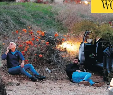  ?? JACK GUEZ / AFP / GETTY IMAGES ?? Israelis take cover as rockets are fired from the Gaza Strip into the southern Israeli town of Sderot on Monday, after an attempted incursion into Gaza by Israeli commandos on Sunday night went wrong.