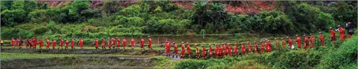  ?? PHOTOS PROVIDED BY NANNING FIRE AND RESCUE TO CHINA DAILY ?? Rescuers file across the mountainsi­de in a line.