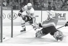  ?? Tom Mihalek/ Associated Press ?? ■ Pittsburgh Penguins’ Sidney Crosby, left, scores past Philadelph­ia Flyers’ Michal Neuvirth during the first period in Game 6 of an NHL first-round hockey playoff series Sunday in Philadelph­ia.