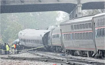  ?? REUTERS ?? Emergency responders attend the scene after an Amtrak passenger train collided with a freight train and derailed in Cayce, South Carolina on Sunday.