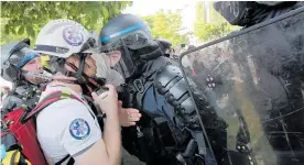  ?? Photo / AP ?? Riot police confront a first aid volunteer after clashes in Paris.