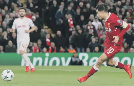  ??  ?? Philippe Coutinho slides home his second goal in Liverpool’s Anfield rout of Spartak Moscow last night.