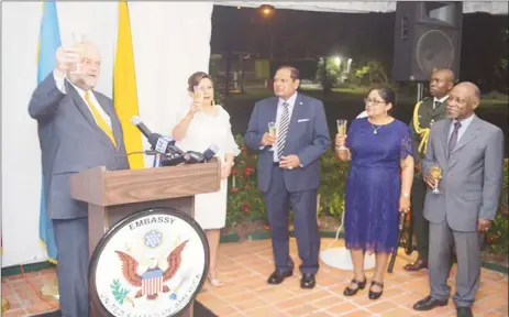  ??  ?? Outgoing US Ambassador Perry Holloway (left) speaking at the farewell reception hosted by the US Embassy on Friday evening. His wife Rosaura is second from left. Also in photo are Prime Minister Moses Nagamootoo (third, from right), his wife Sita (second, from right) and Foreign Affairs Minister Carl Greenidge (right). (Department of Public Informatio­n photo)