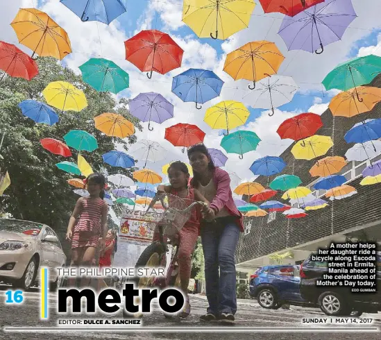  ?? EDD GUMBAN ?? A mother helps her daughter ride a bicycle along Escoda street in Ermita, Manila ahead of the celebratio­n of Mother’s Day today.