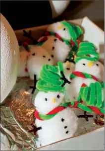  ??  ?? Handmade snowmen wait to be hung on Christmas trees.