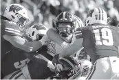  ?? STACY REVERE Getty Images ?? Iowa’s Spencer Petras is smothered by Wisconsin defenders Saturday as the Badgers claimed the Heartland Trophy, given annually to the winner of the rivalry.