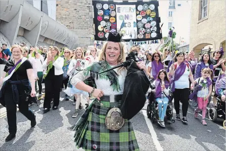  ?? JEFF J MITCHELL GETTY IMAGES ?? A bagpiper leads marchers in Edinburgh, Scotland, on Sunday marking 100 years since women won the right to vote in the U.K. Women marched in the colours of the suffragett­e movement — purple, white and green — to create a living artwork to mark the...