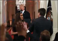  ?? AP/EVAN VUCCI ?? A White House intern reaches to take the microphone away from CNN correspond­ent Jim Acosta during Wednesday’s news conference.