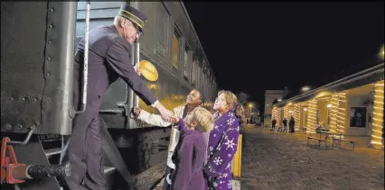  ?? GRAND CANYON RAILWAY ?? Passengers in robes and pajamas board the Grand Canyon Railway’s Polar Express train in Williams, Arizona.