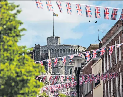  ??  ?? All eyes: the streets, shops and pubs of Windsor decked out in royal memorabili­a ahead of the wedding of Prince Harry and Meghan Markle
