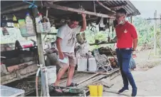  ??  ?? Brolin (right) chats with a villager during the distributi­on of face masks in Serian.