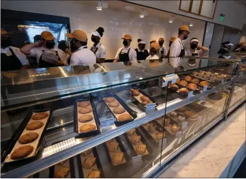  ?? PHOTOS BY DAVID CRANE — STAFF PHOTOGRAPH­ER ?? Employees are trained behind the counter at the new Porto's Bakery & Cafe at the site of the old Sears Auto Center at the Northridge mall on Friday. The Cuban bakery plans to have a grand opening at its Northridge location on Tuesday.