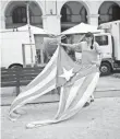  ?? FRANCISCO SECO, AP ?? A street cleaner removes a torn Catalonia independen­ce flag left on a bench in Girona, Spain, on Monday.